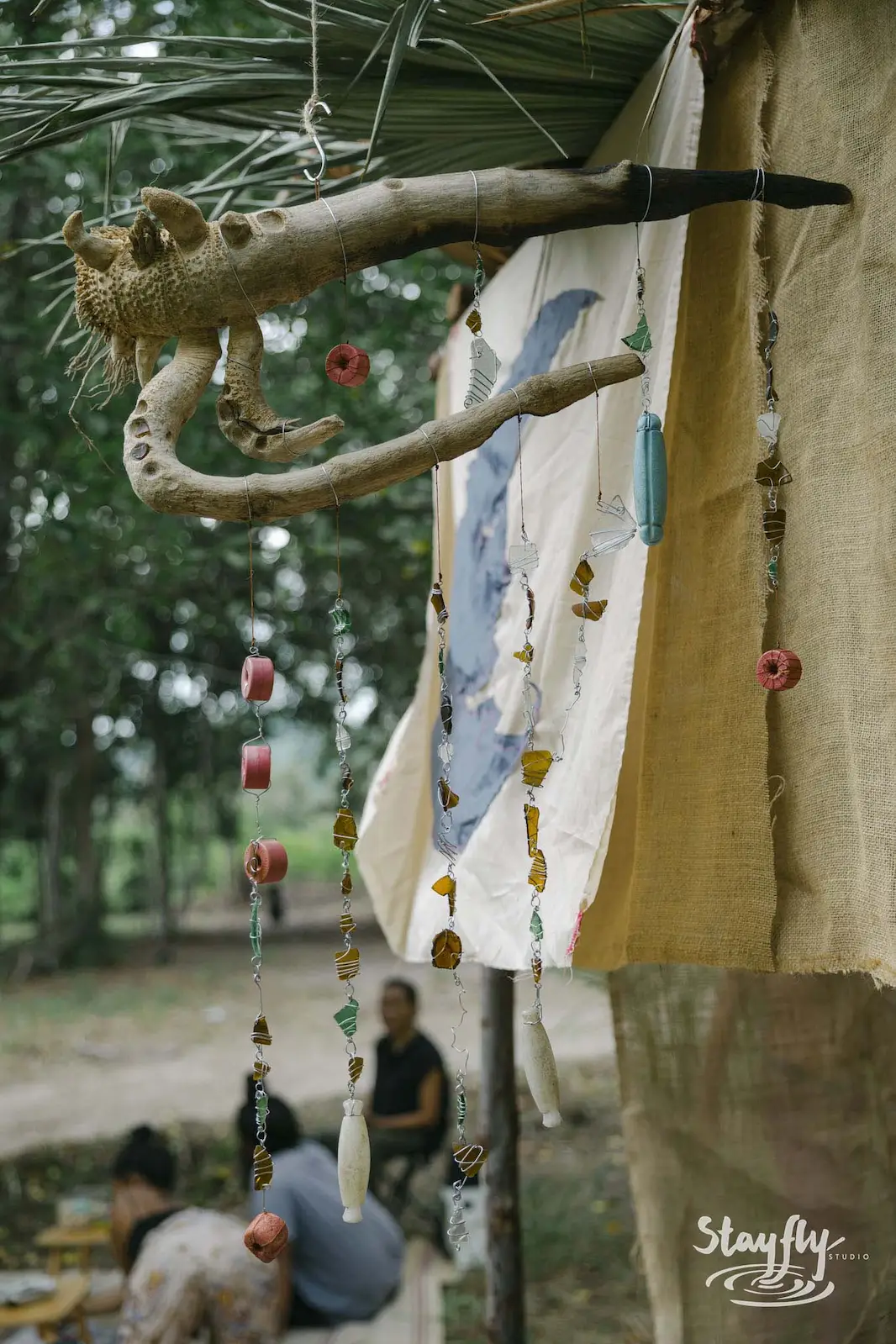 Wooden carved creature decor hanging with fabric banner.