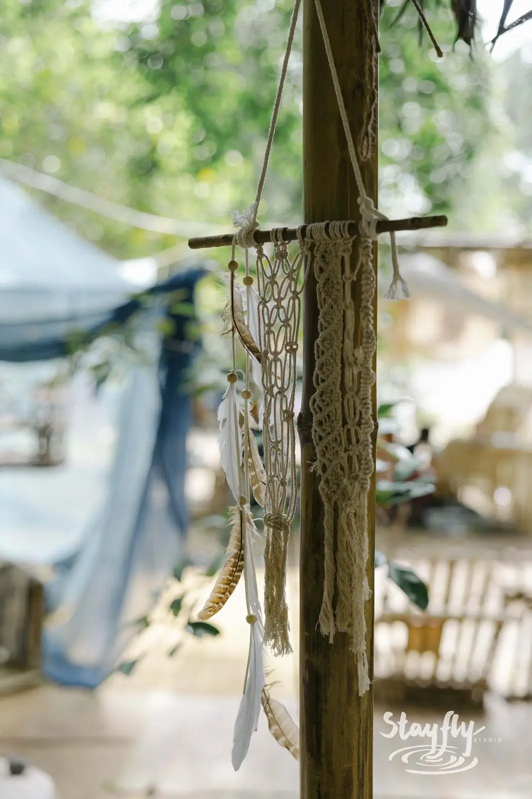 Macrame dreamcatcher hanging from wooden post.