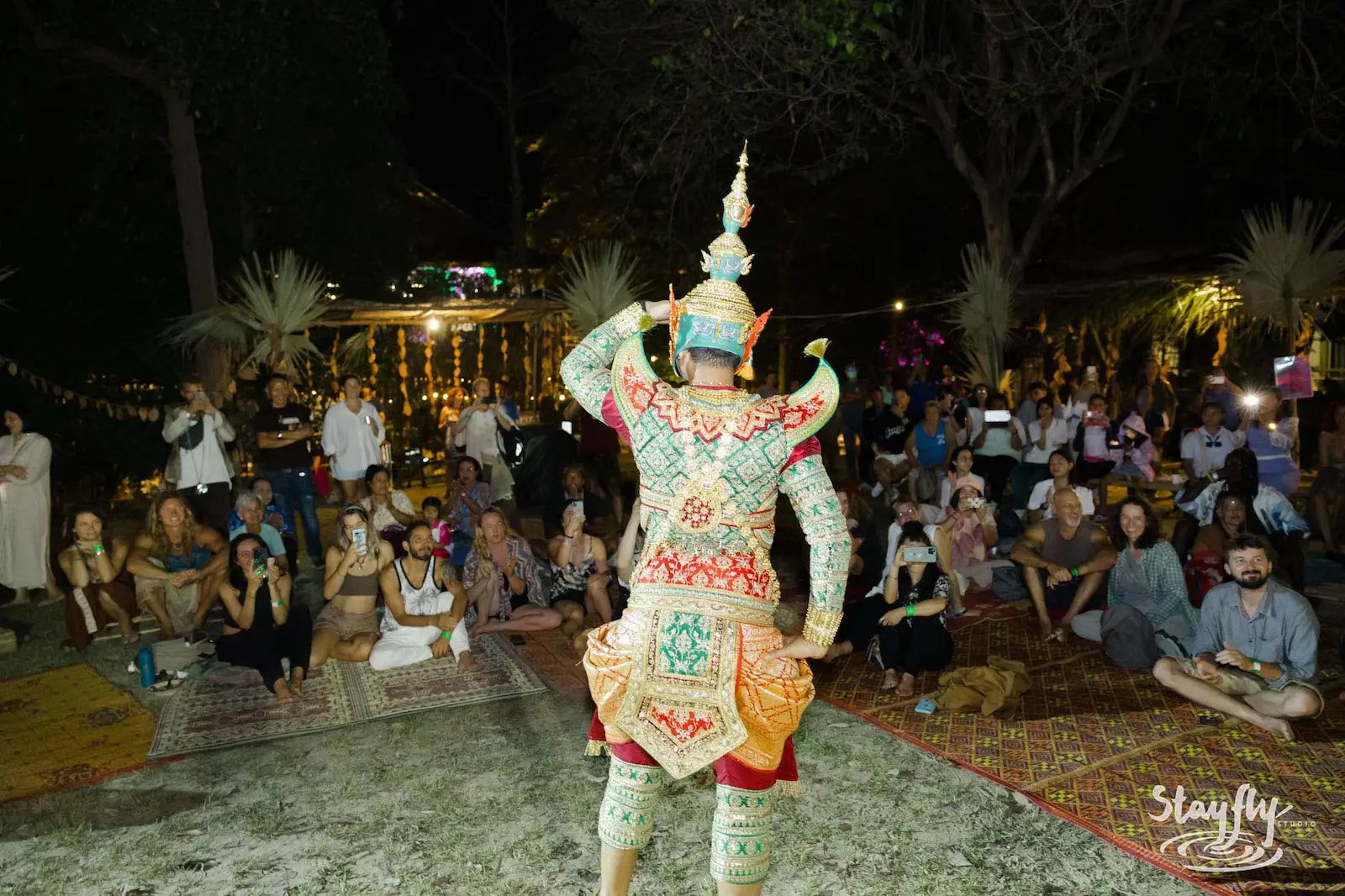 Khon dancer in ornate costume performs for crowd.
