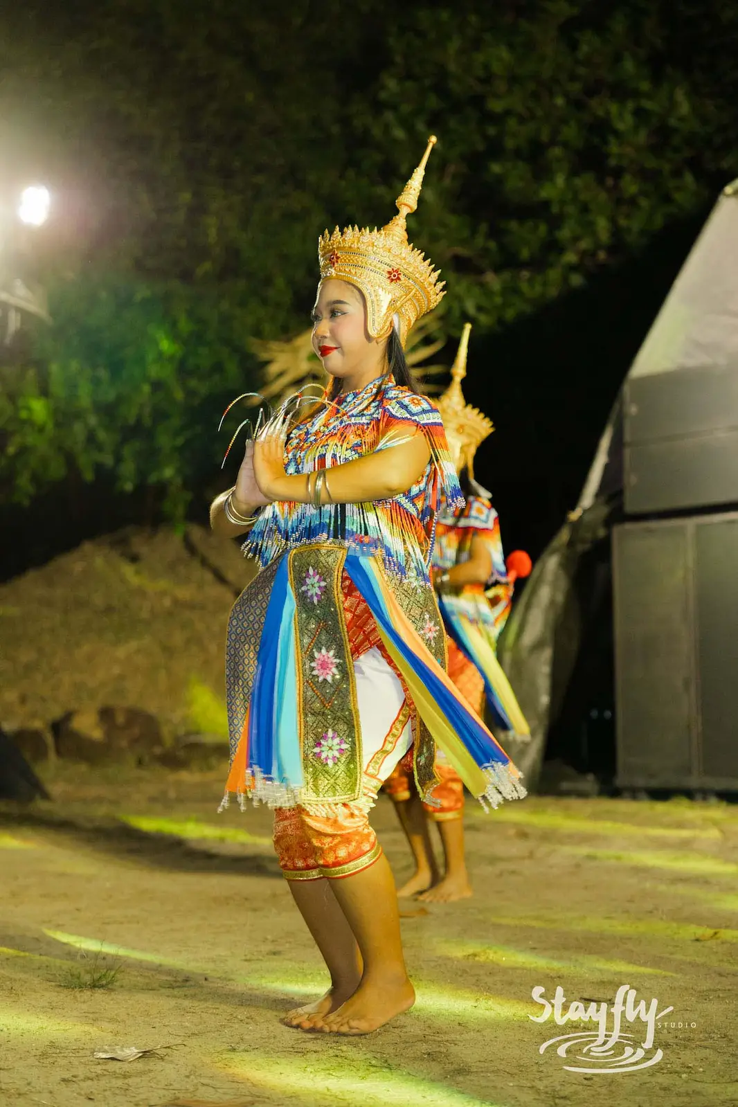 Dancer in gold Thai costume mid-performance.