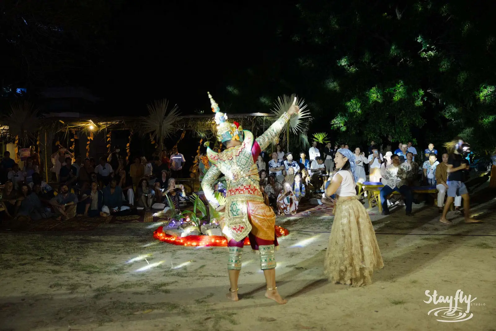 Masked Khon dancer performing at night before audience.