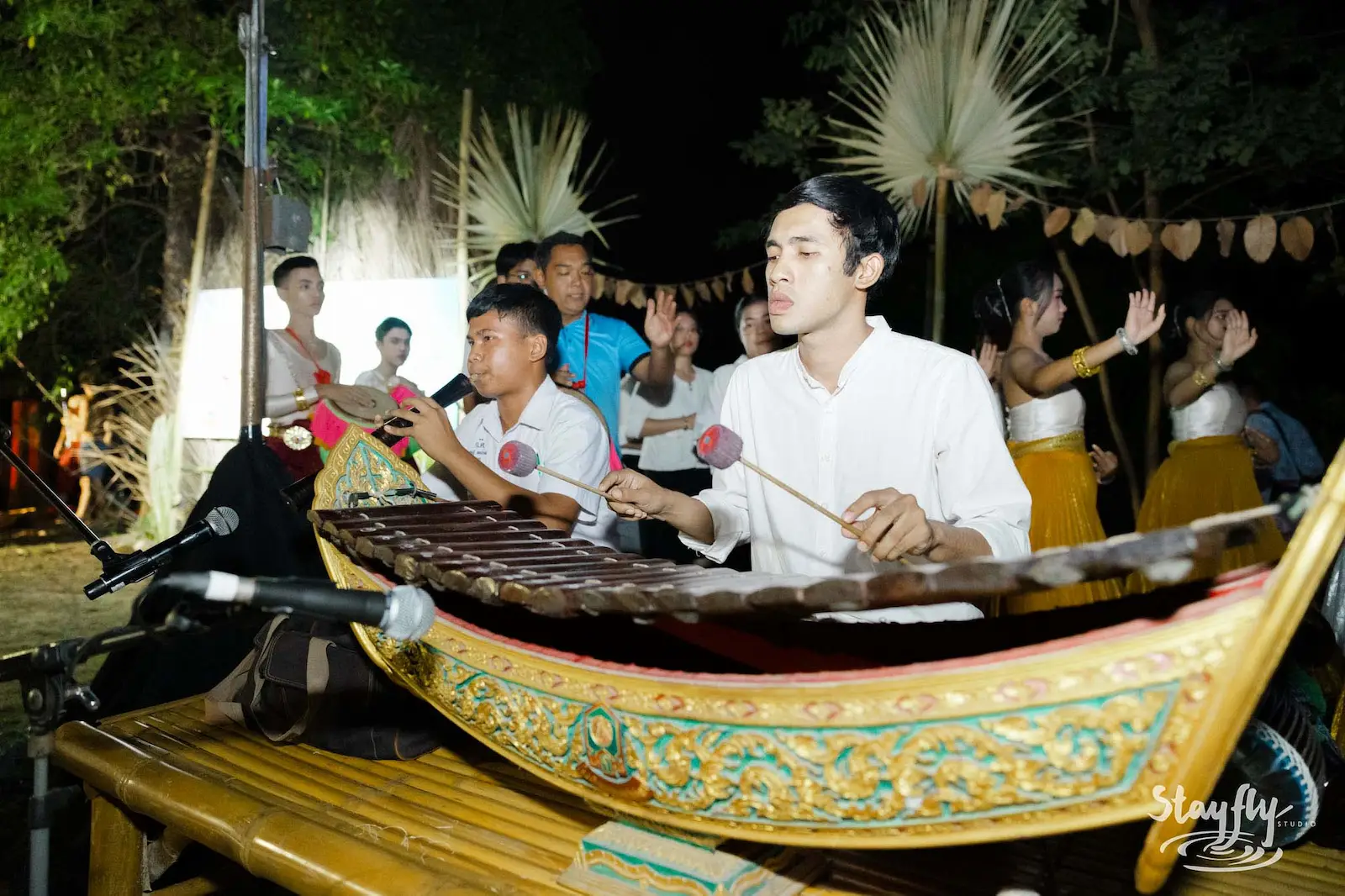 Musicians playing traditional Thai xylophone at night.
