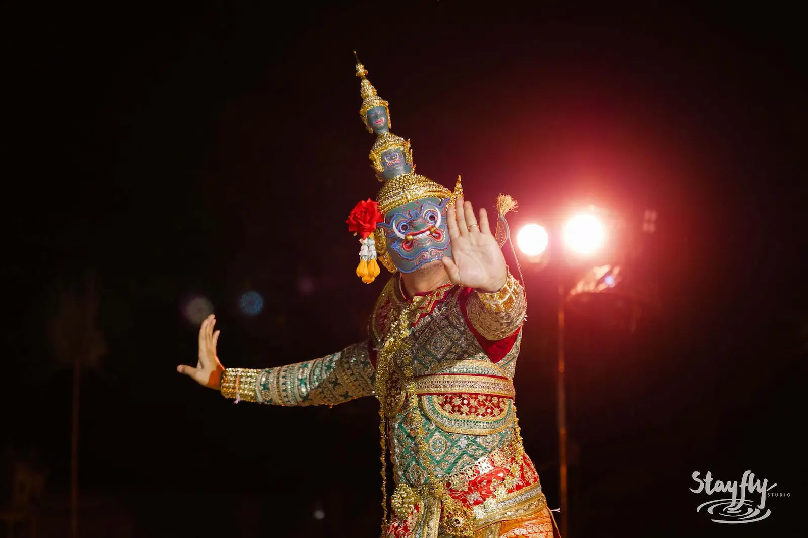 Masked khon dancer performing at night.