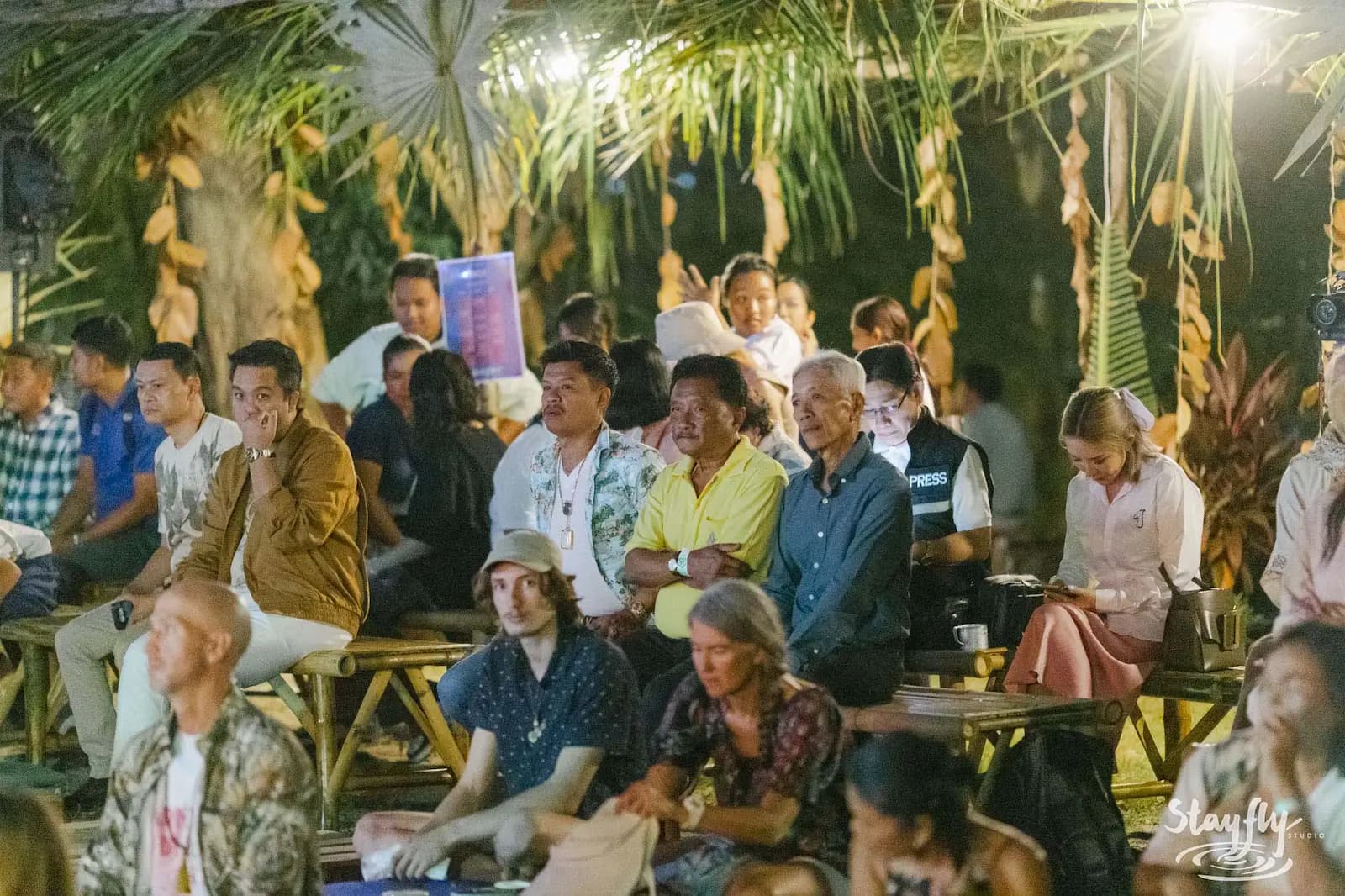 Seated audience listening at daytime outdoor talk.
