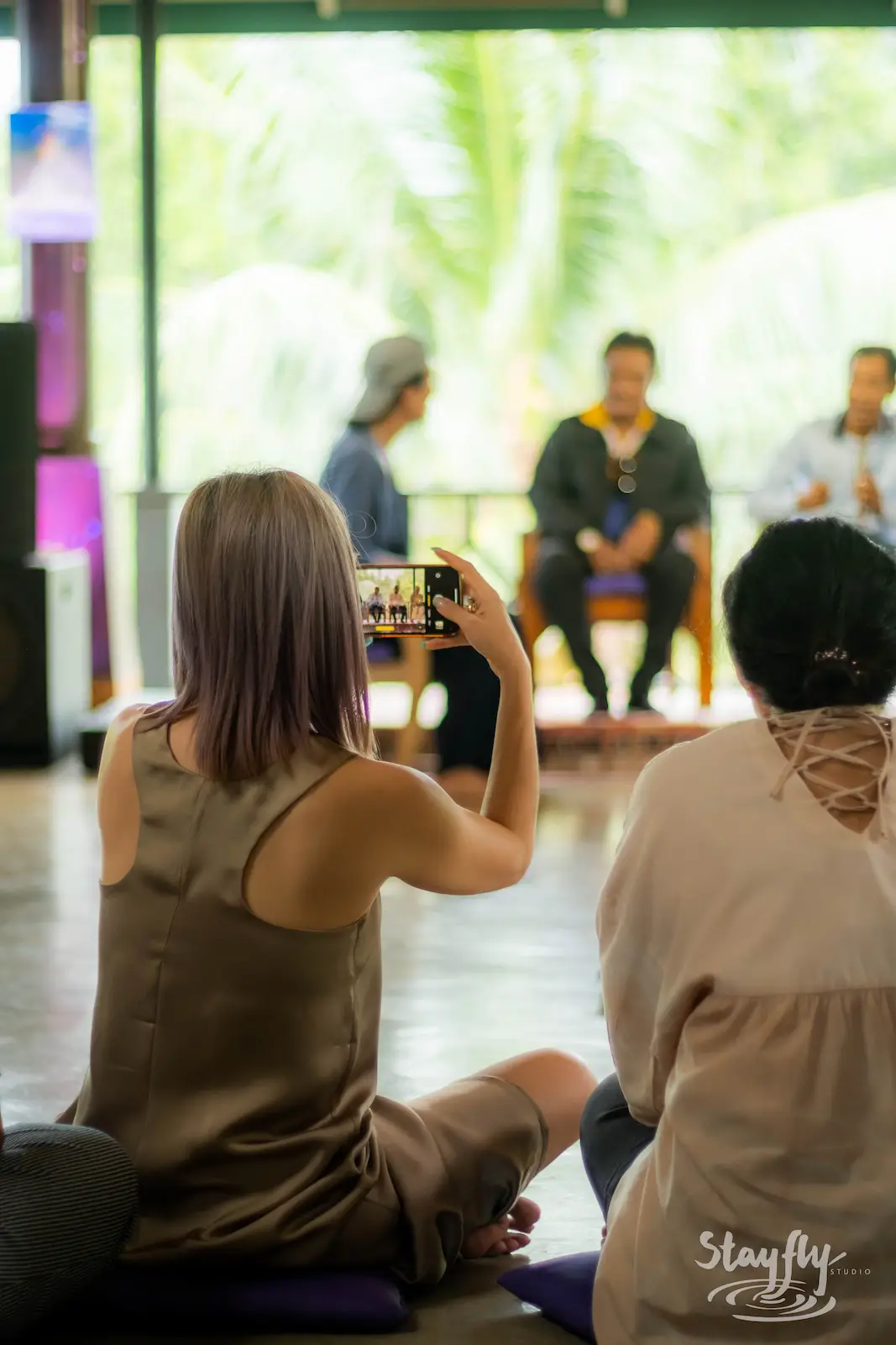 Audience member photographing a panel talk.