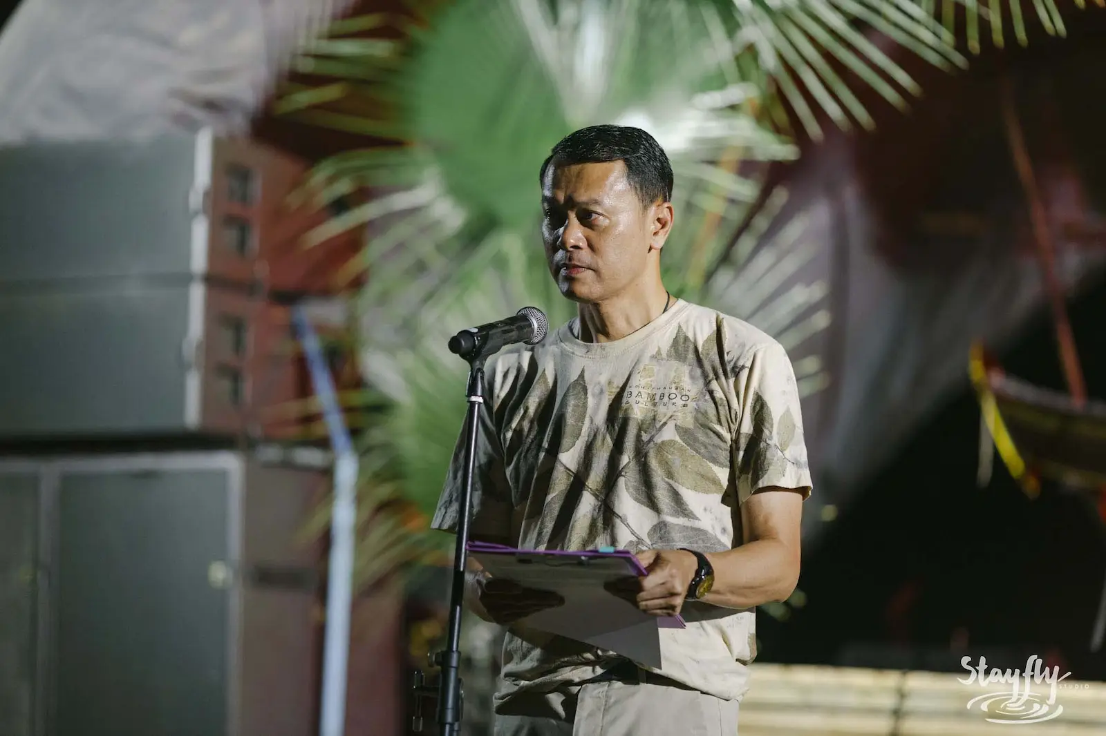 Man reading announcement at microphone.