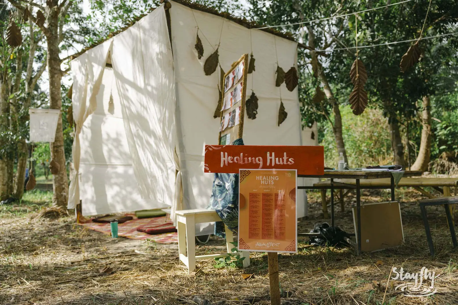 Healing Huts signpost beside white fabric shelter.