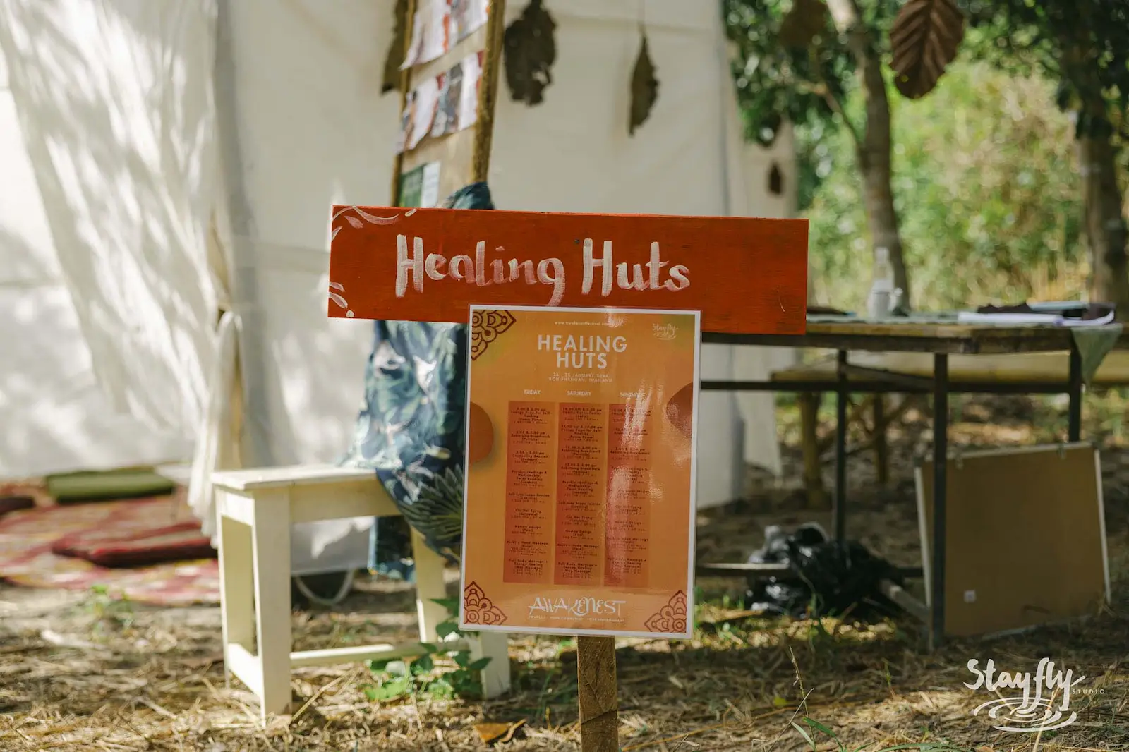 Healing Huts sign with a schedule board.