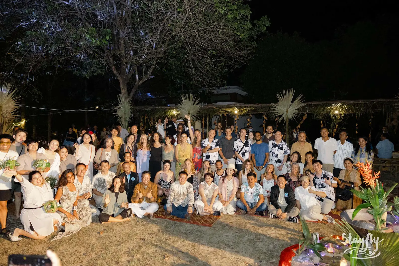 Large formal group photo at night outdoors.