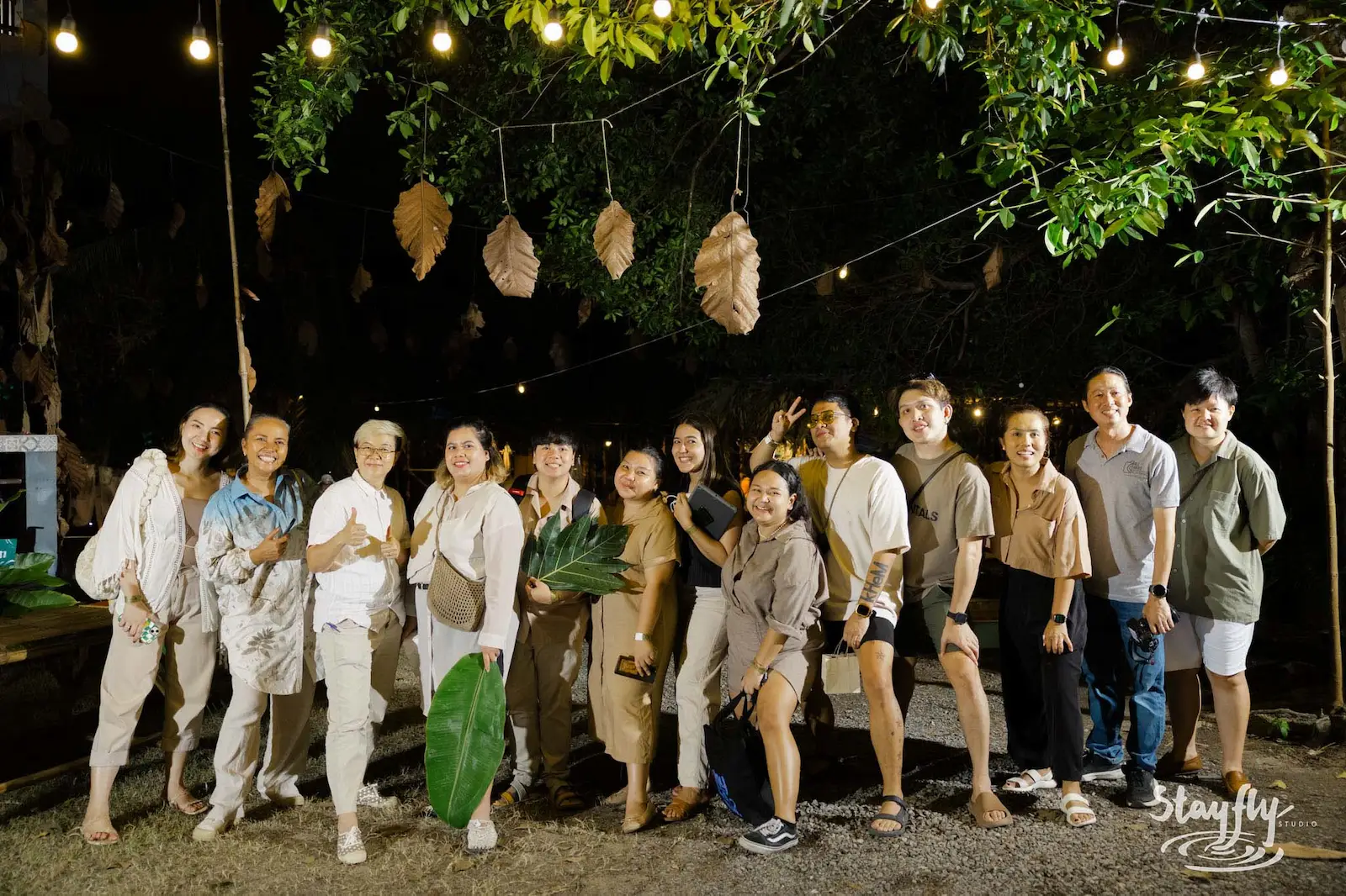 Group portrait posed under string lights at night.