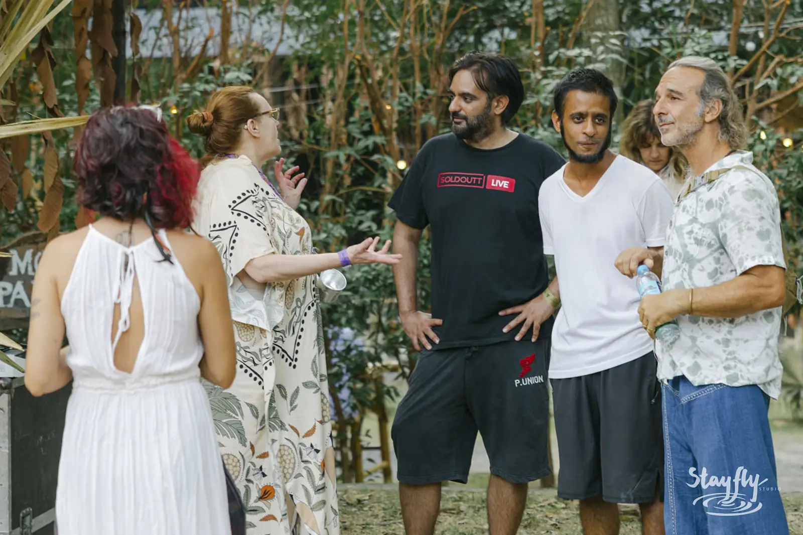 Group of people conversing outdoors in daylight.