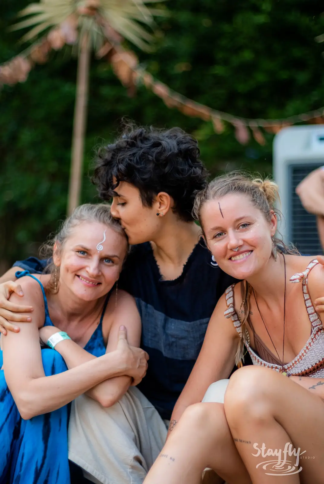 Three women embracing and smiling together.