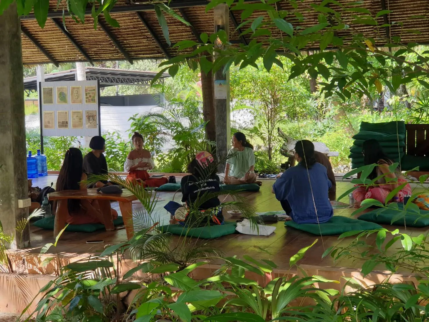 Small group workshop circle under garden shelter.