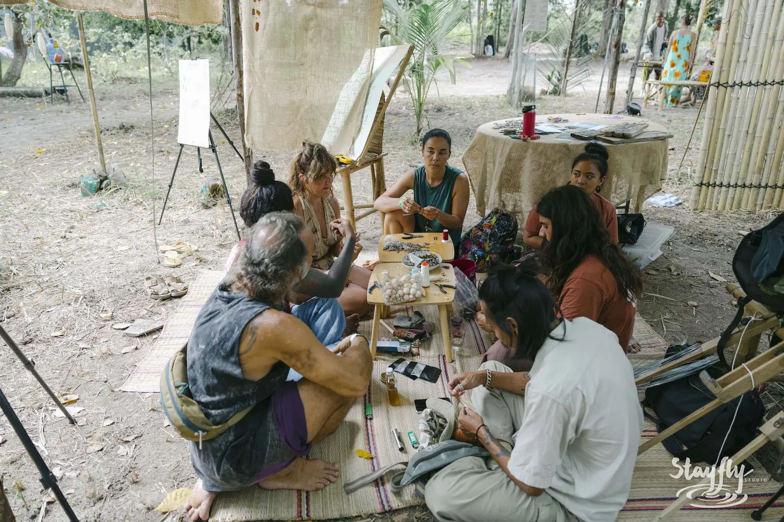 Group painting at easels in forest workshop area.