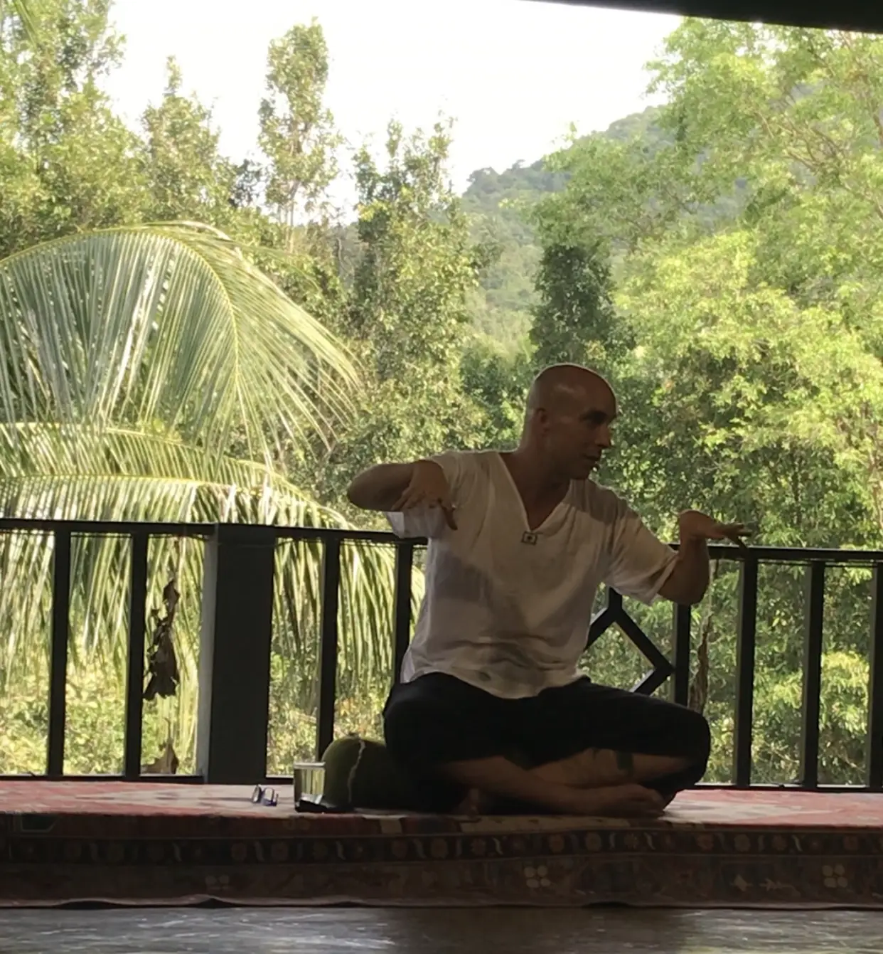 Man practicing tai-chi movement on open deck.