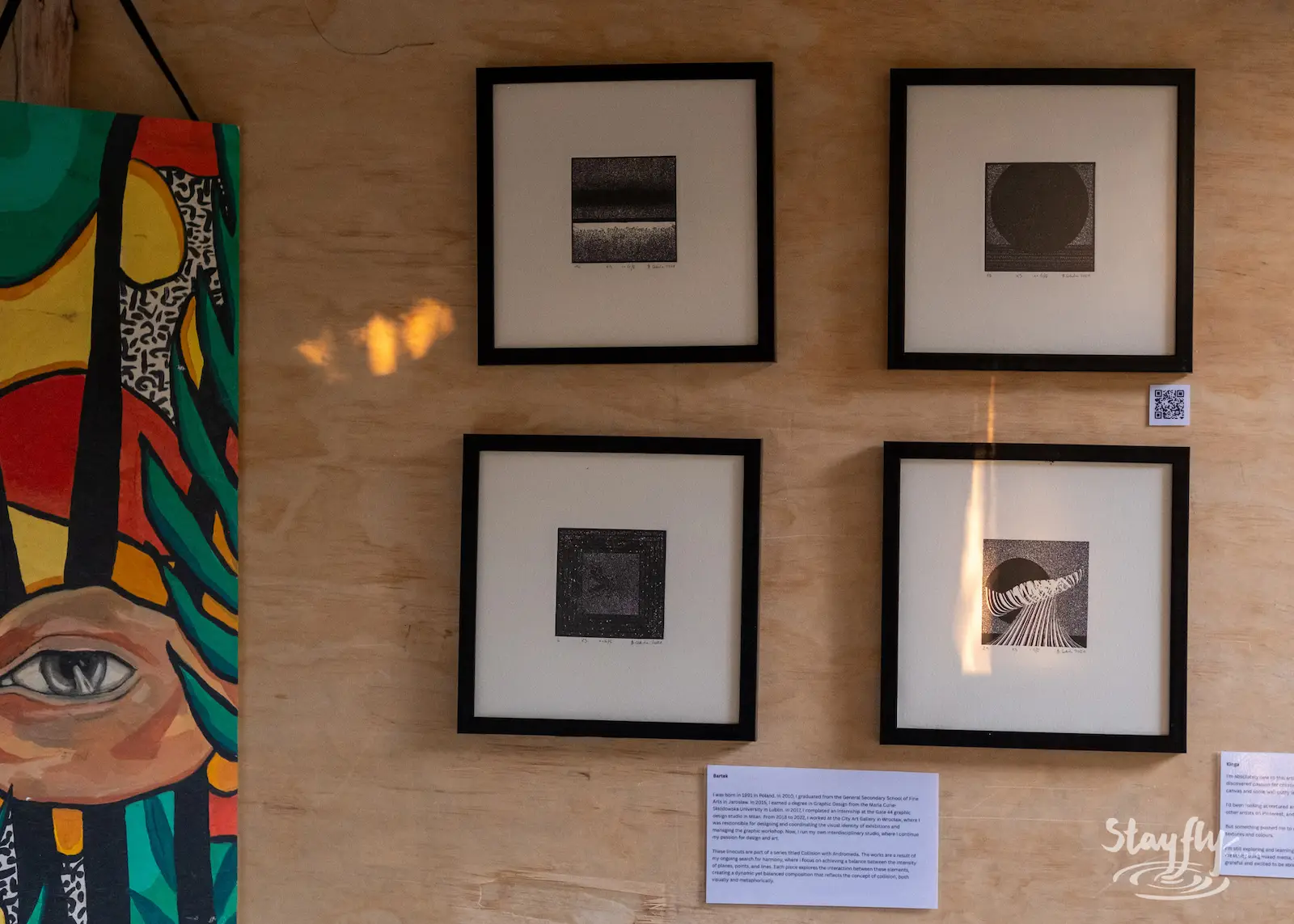 Four framed photographs displayed on wooden wall.