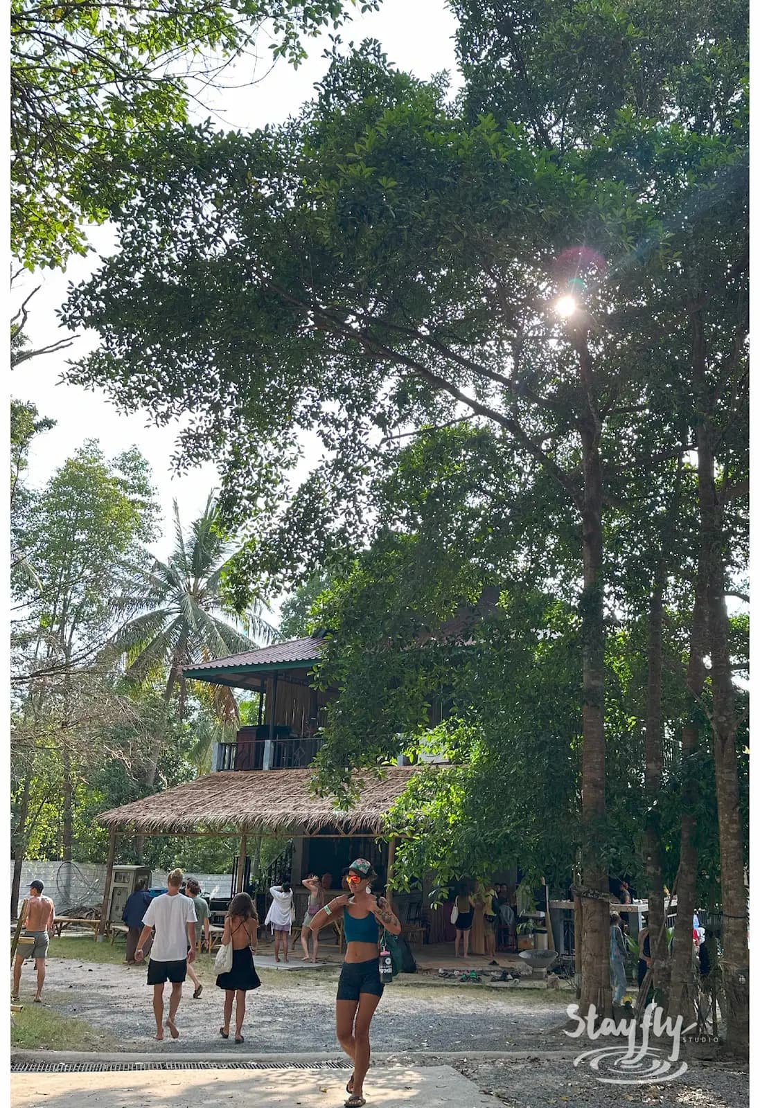 Sunlit path near two-story venue with visitors.