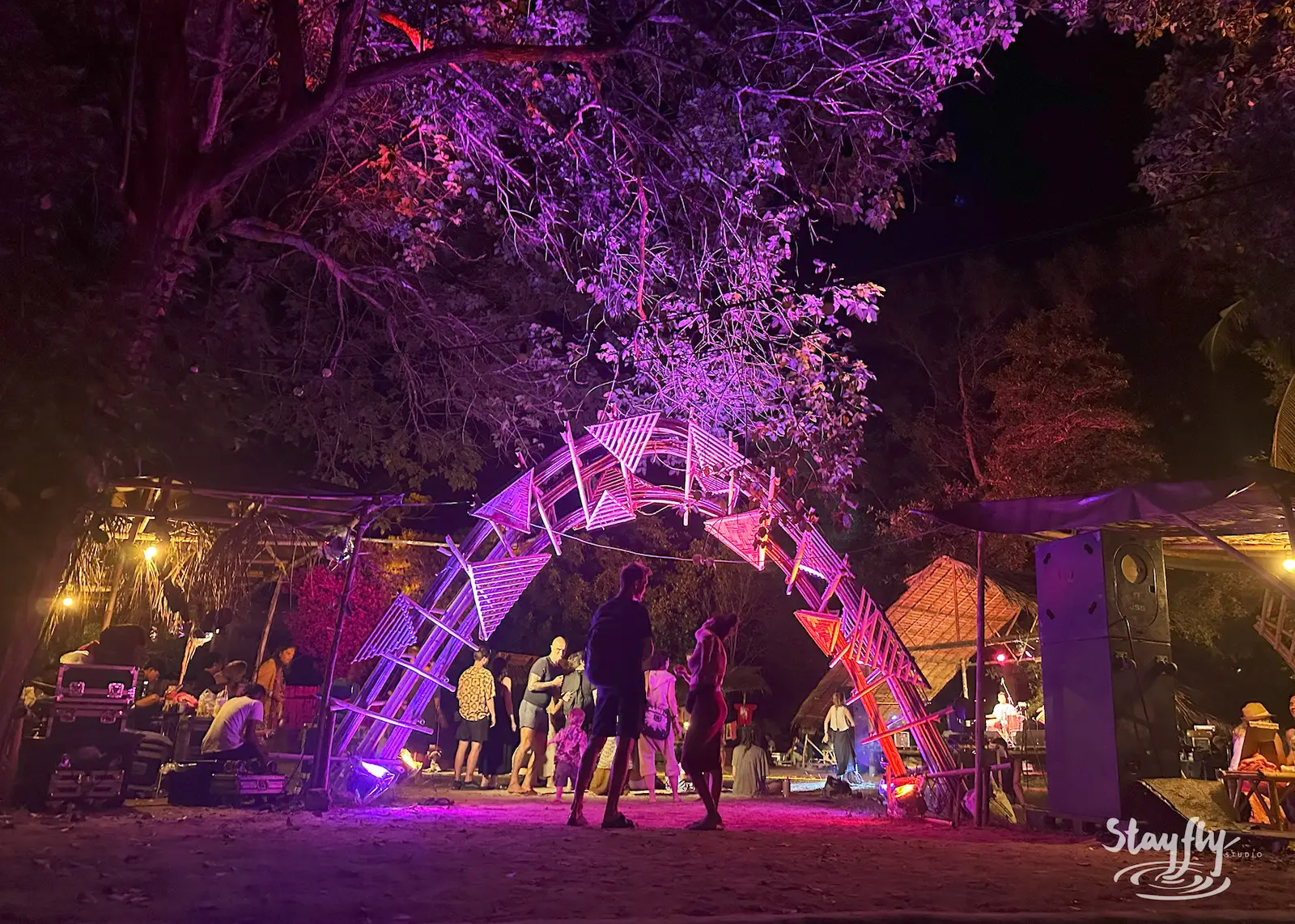 Purple-lit arch installation with people walking through.
