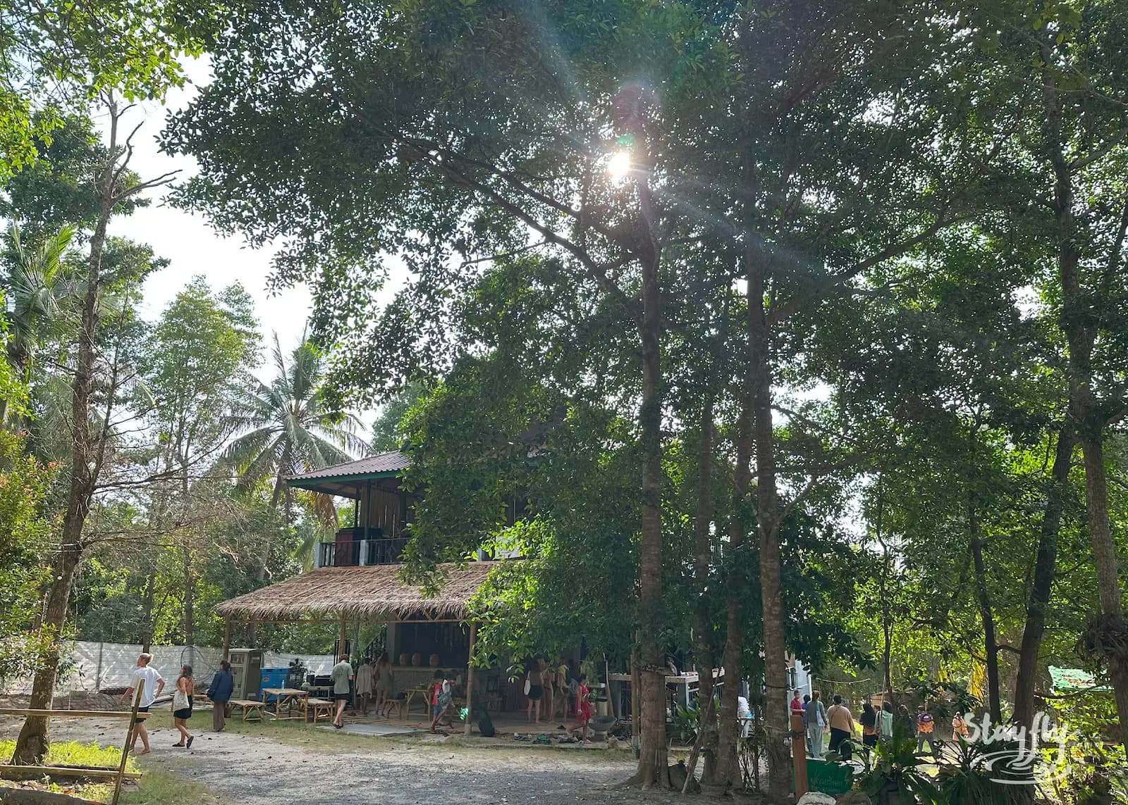 Sunlit two-story wooden venue building, daytime.
