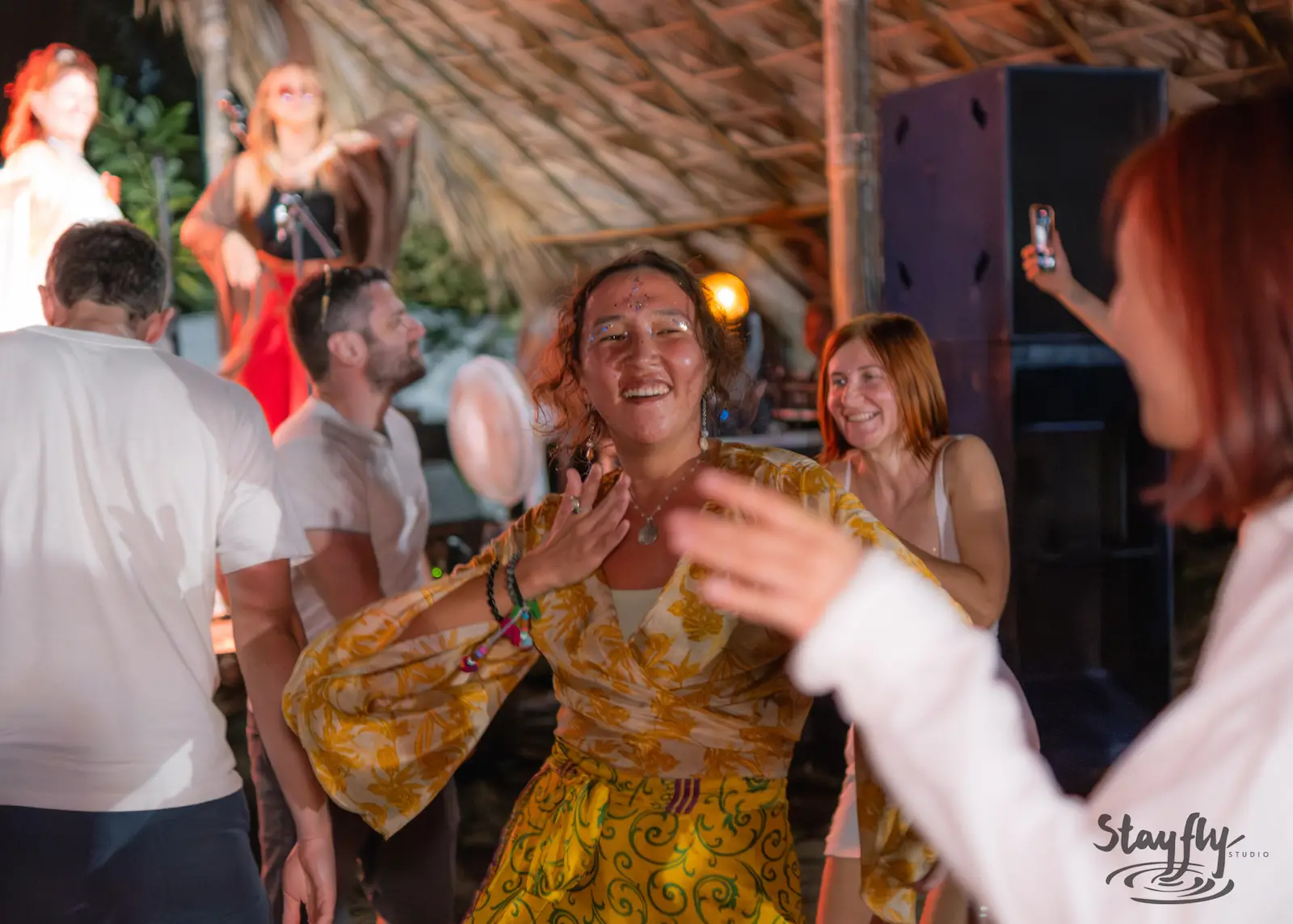 Woman dances joyfully among festival crowd.