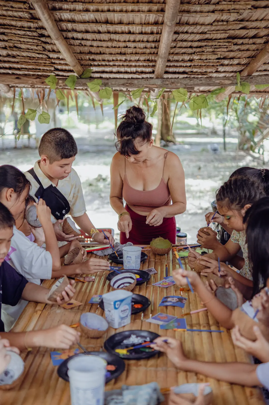 Overhead view of children crafting with adult helper.