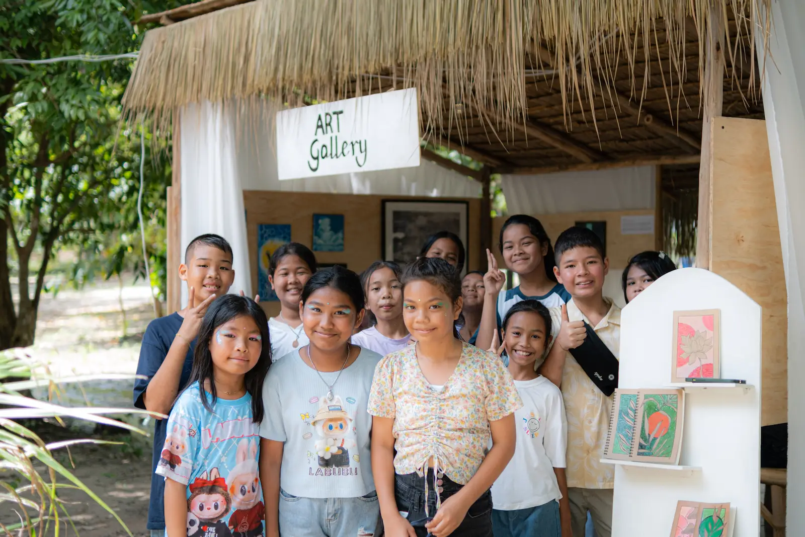 Children pose smiling outside the Art Gallery booth.