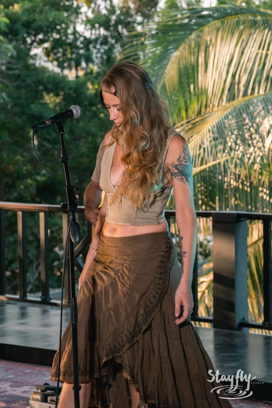 Woman singer performs at sunset on deck.