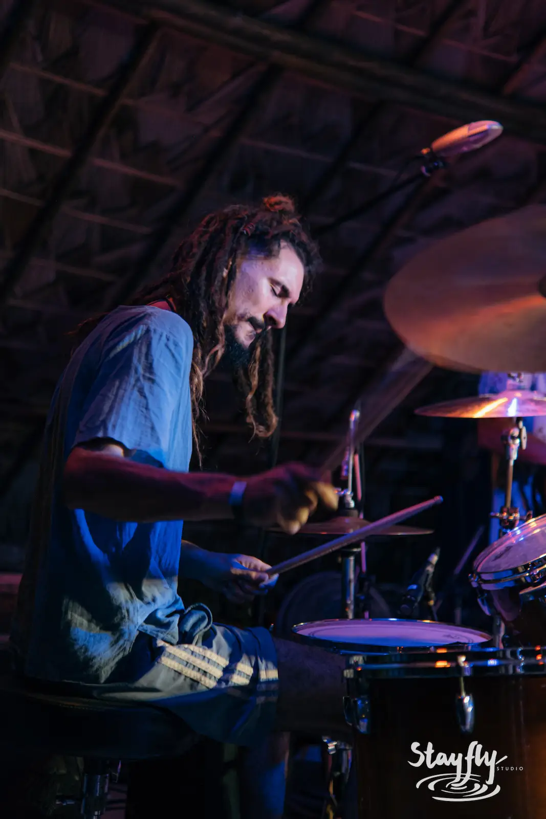 Drummer performing intensely on stage.