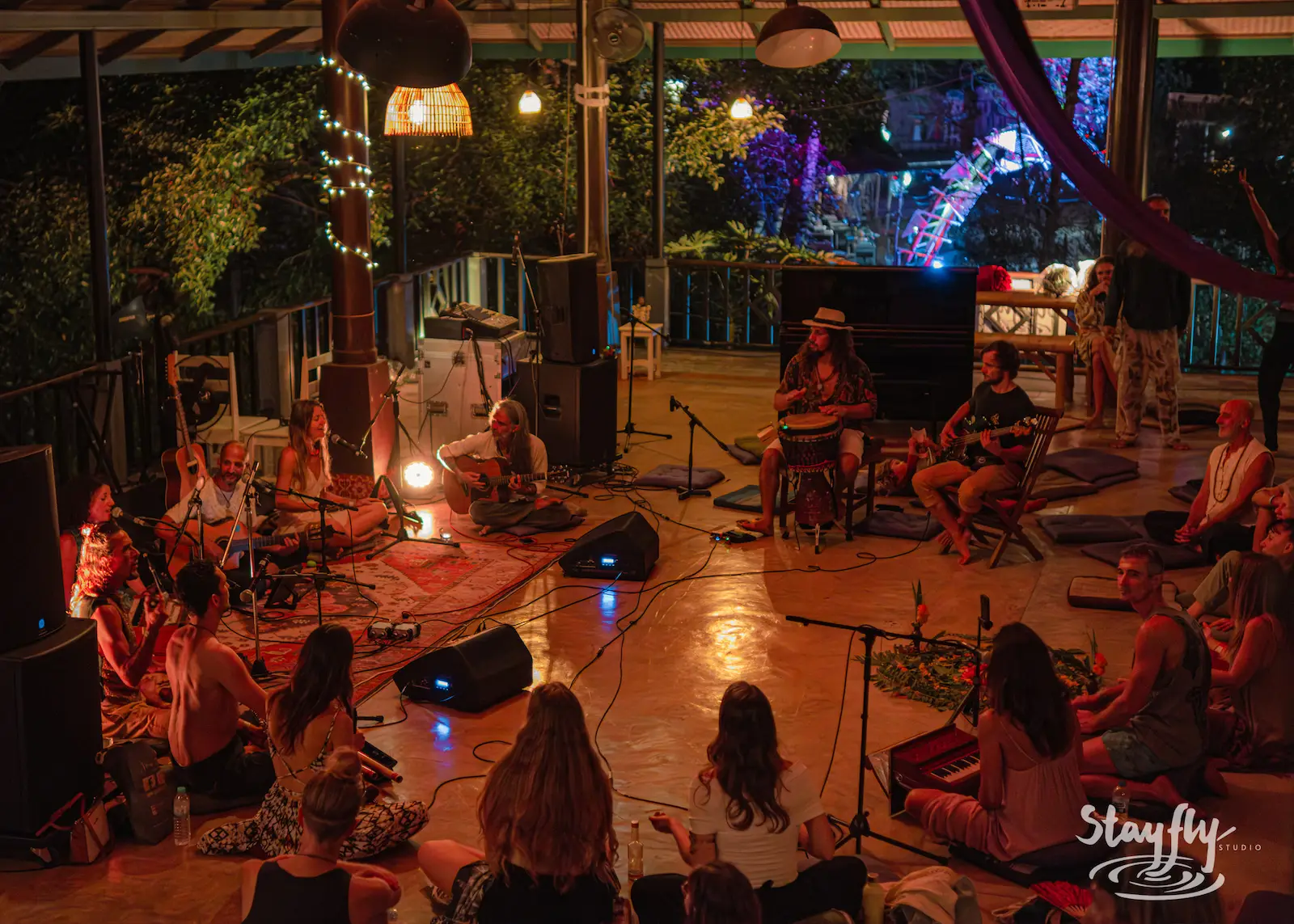 Musicians play to seated audience at night.