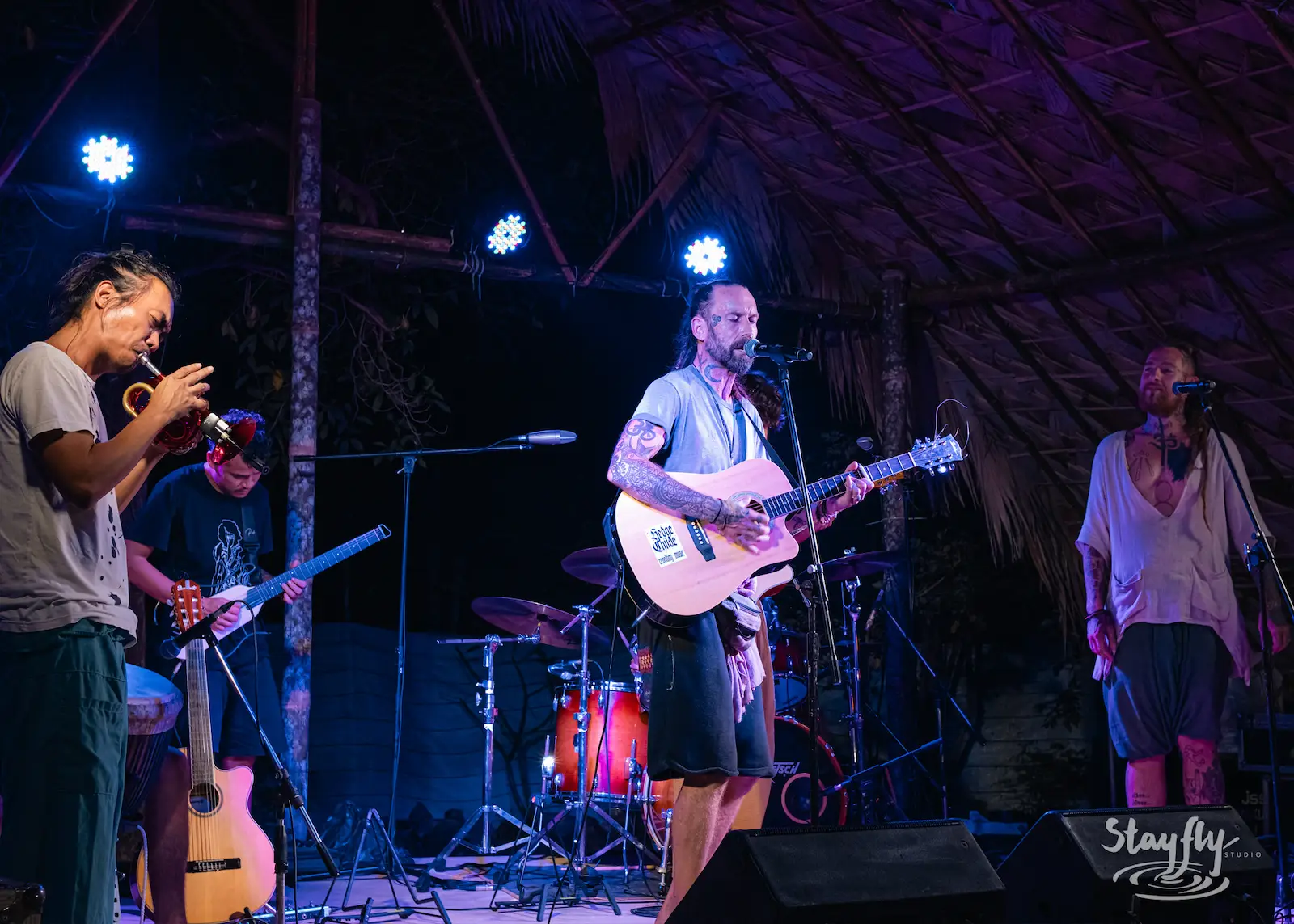 Band performs under thatched roof stage.