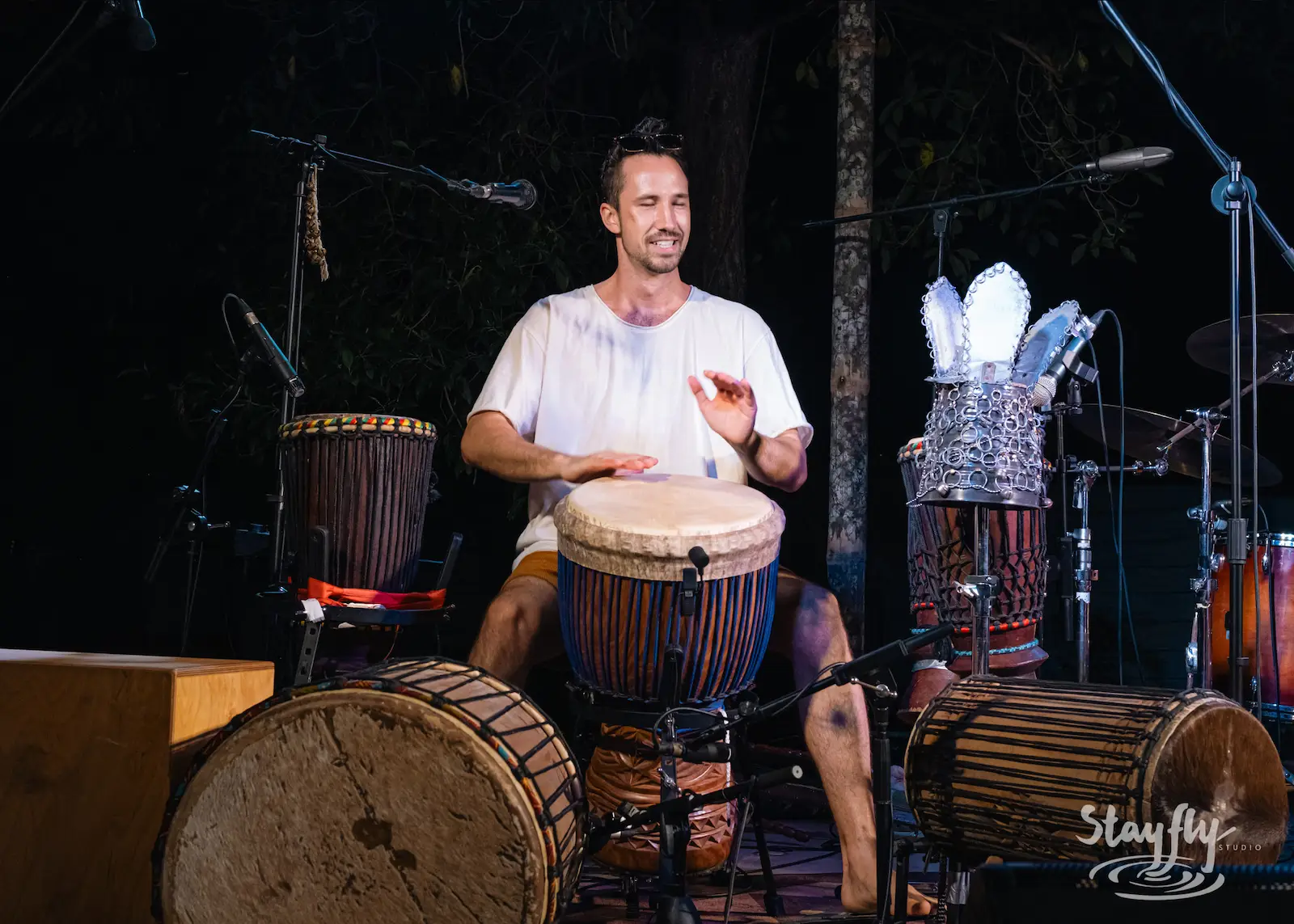 Man playing djembe drums solo on stage.