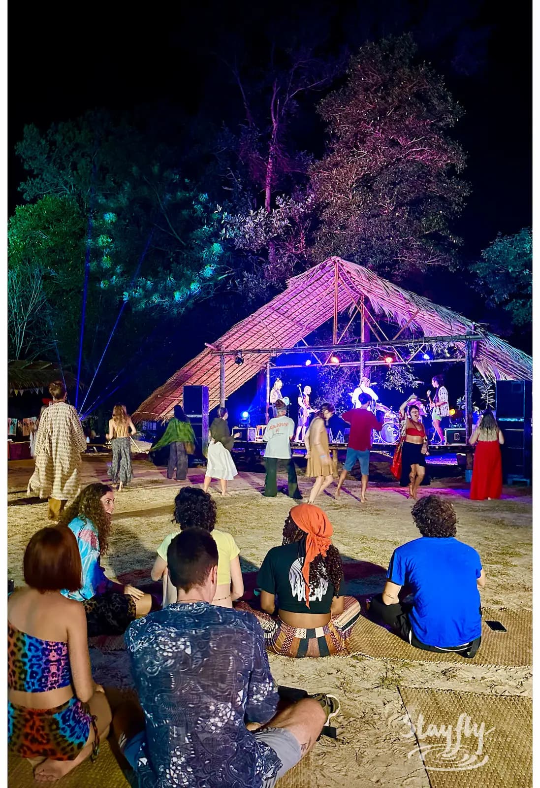 Crowd watching lit stage performance at night.