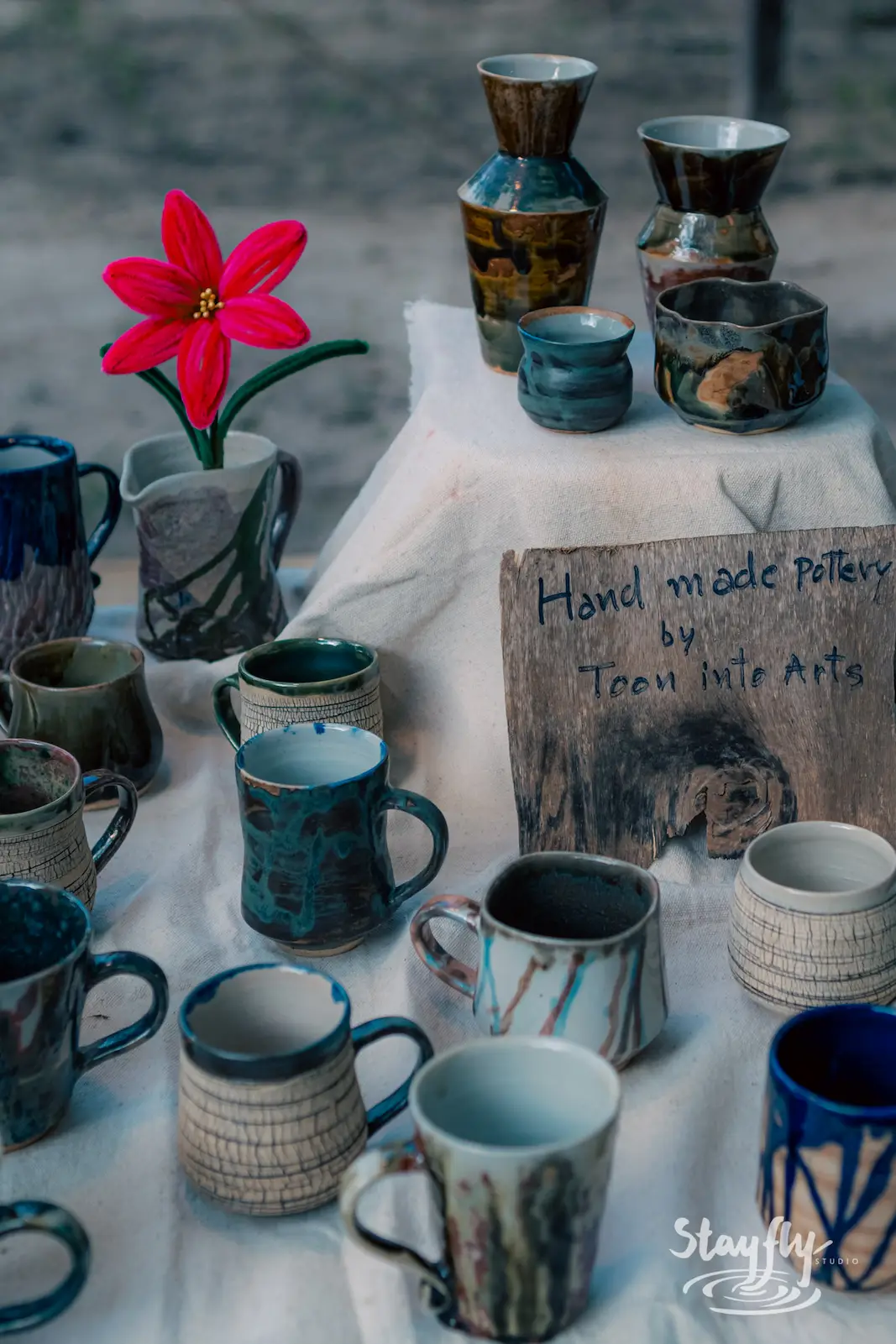 Handmade pottery mugs and vases on display.