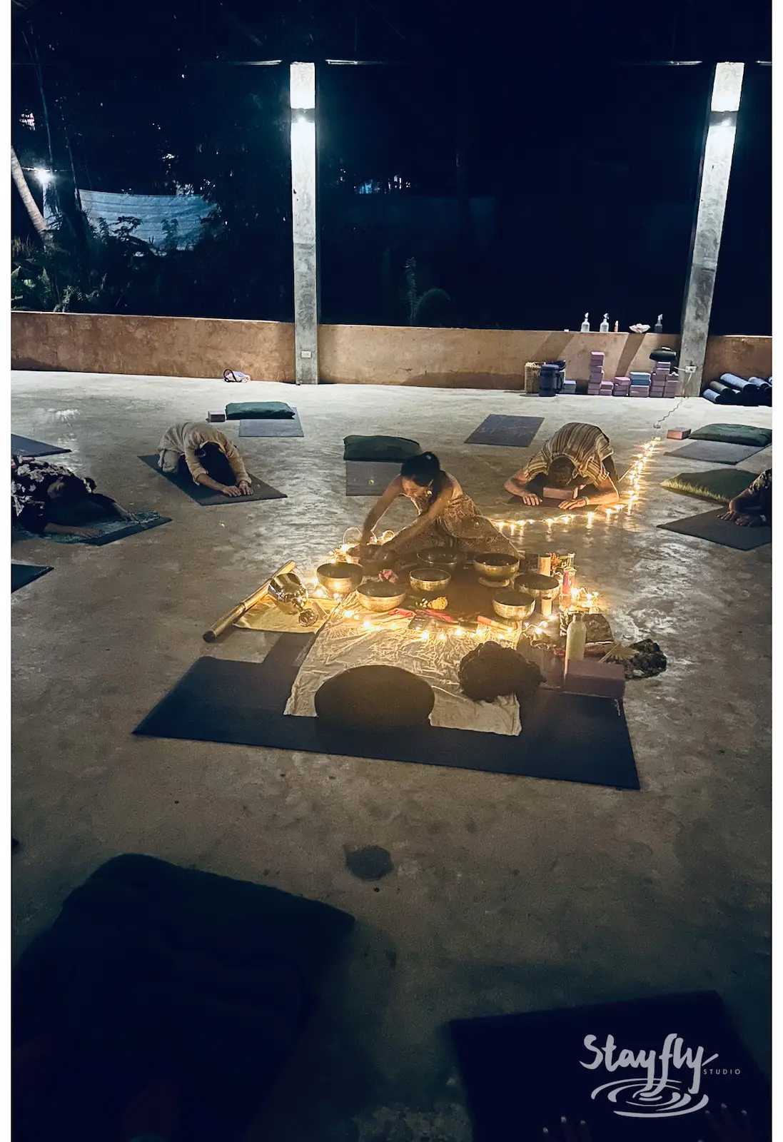 Candlelit circle of mats for evening practice.