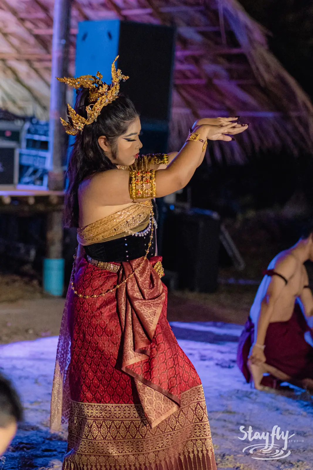 Traditional Thai dancer in gold costume at night.