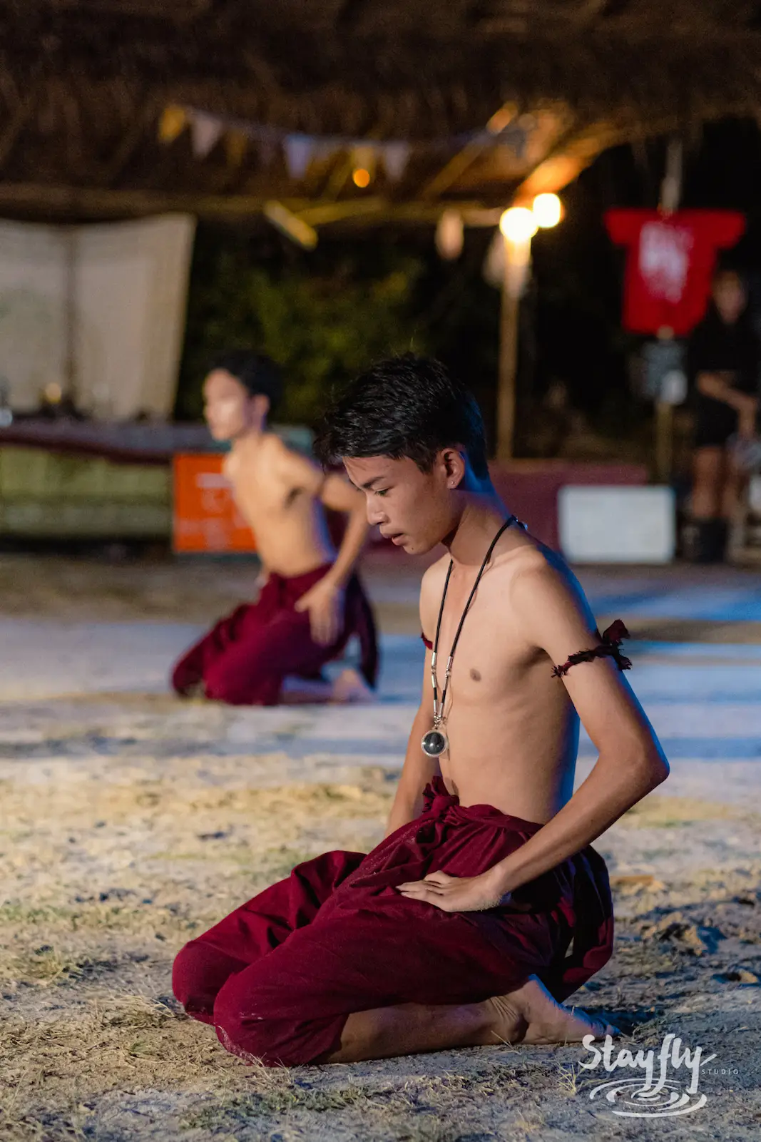 Two young men in maroon robes seated meditatively.