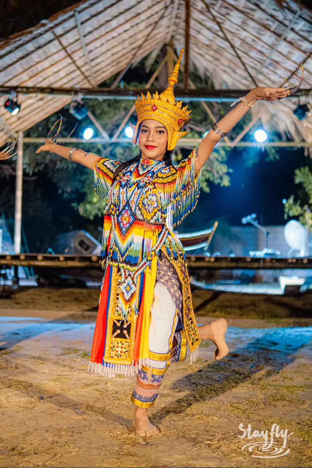 Dancer mid pose with arms raised, one leg lifted.