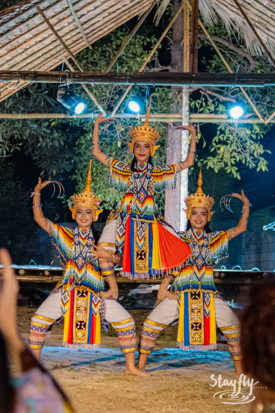 Three crowned dancers performing in unison.