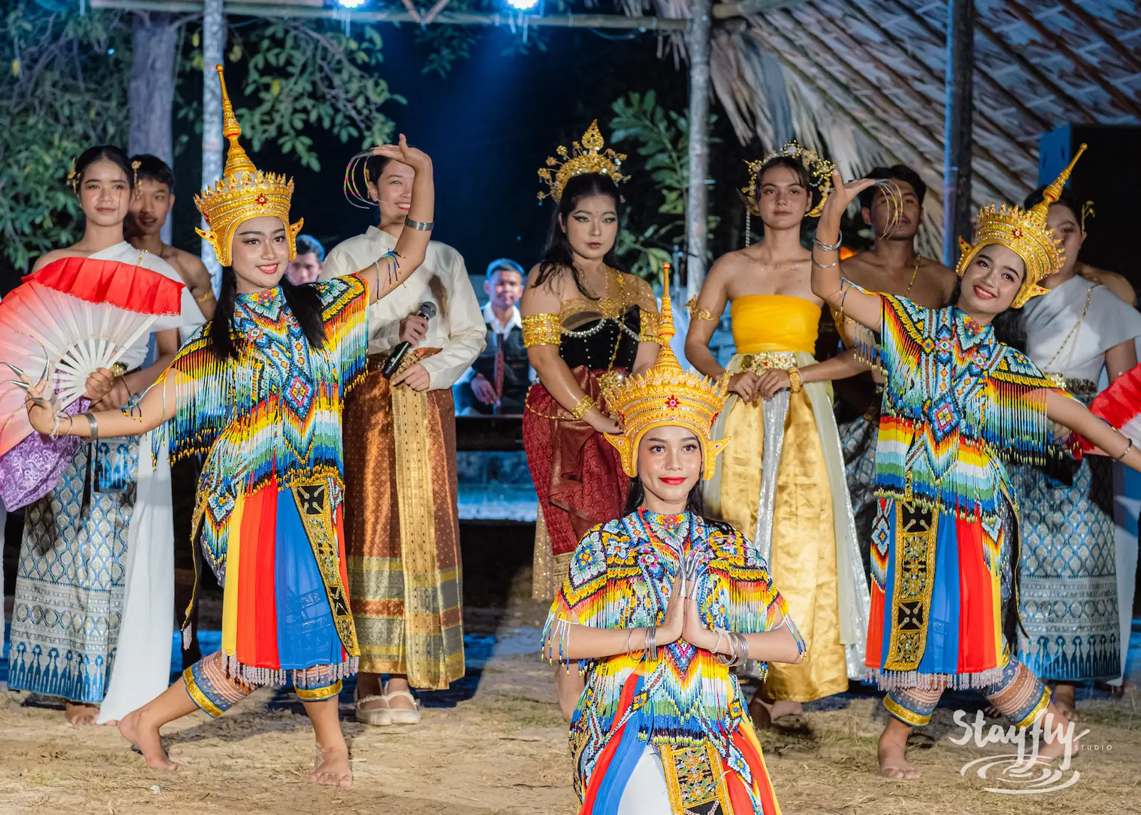 Colorful Thai dance troupe poses on stage.