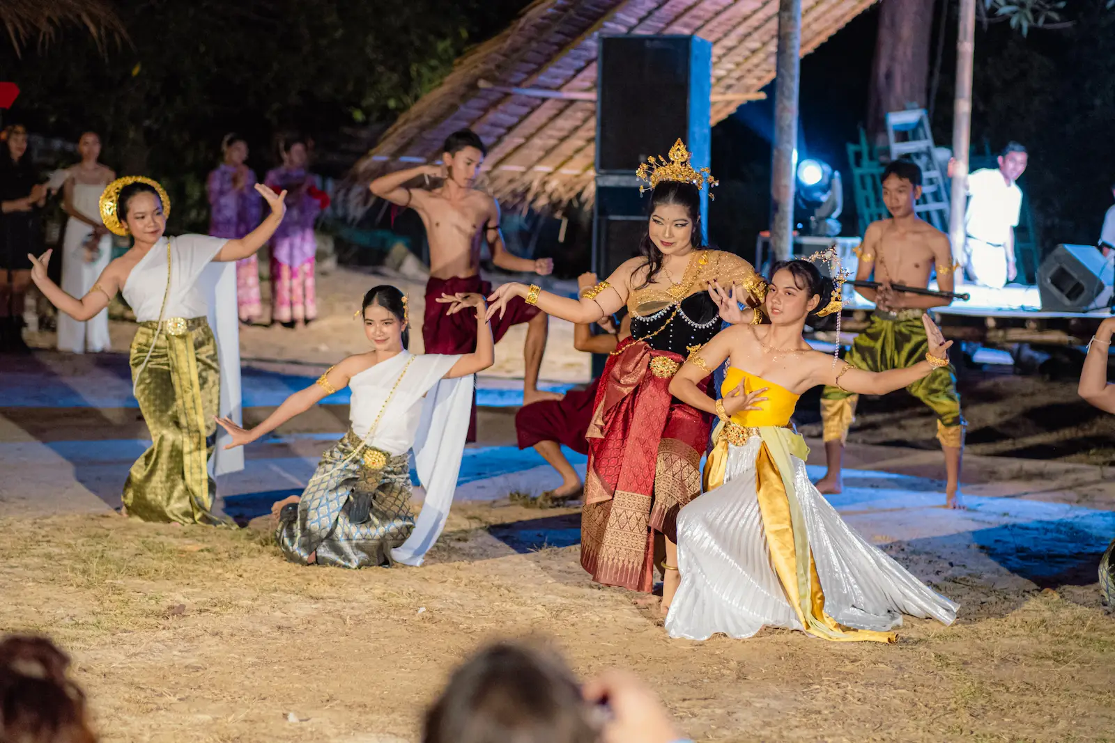 Thai school troupe performs traditional dance on stage.