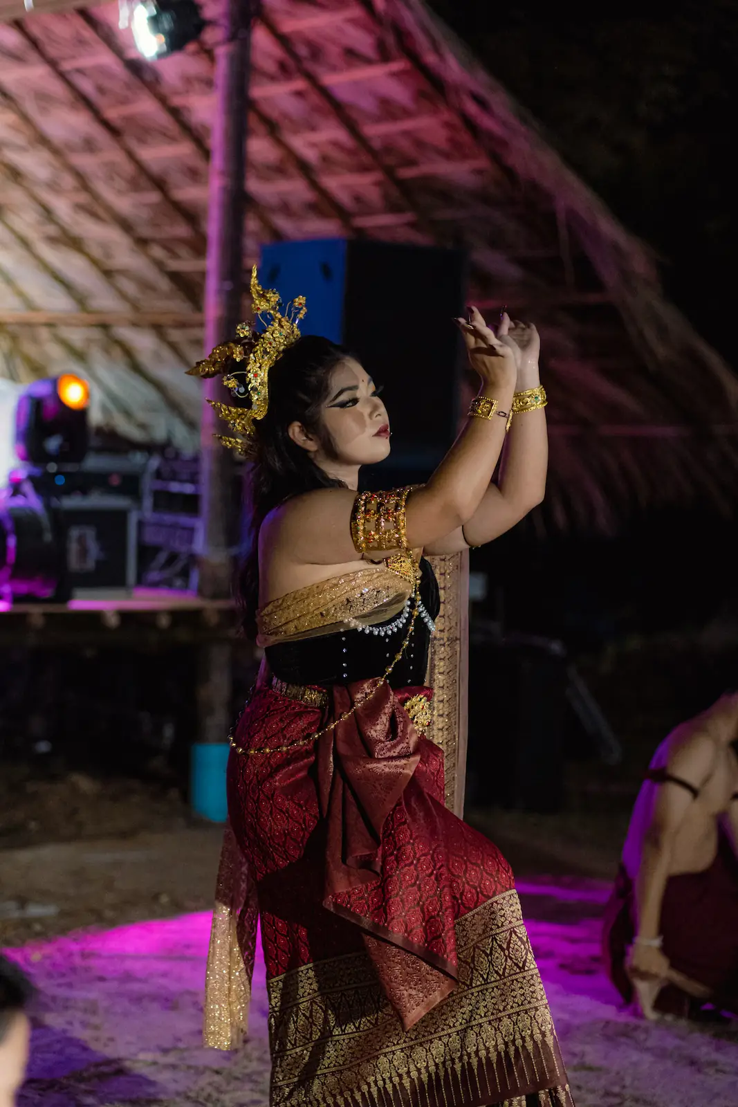 Performer in red and gold dress strikes pose.