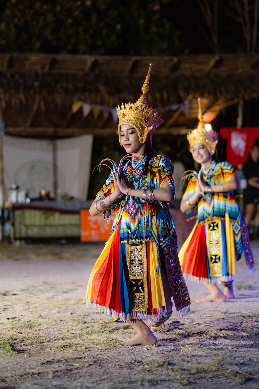 Crowned girl dancer poses with hands together.