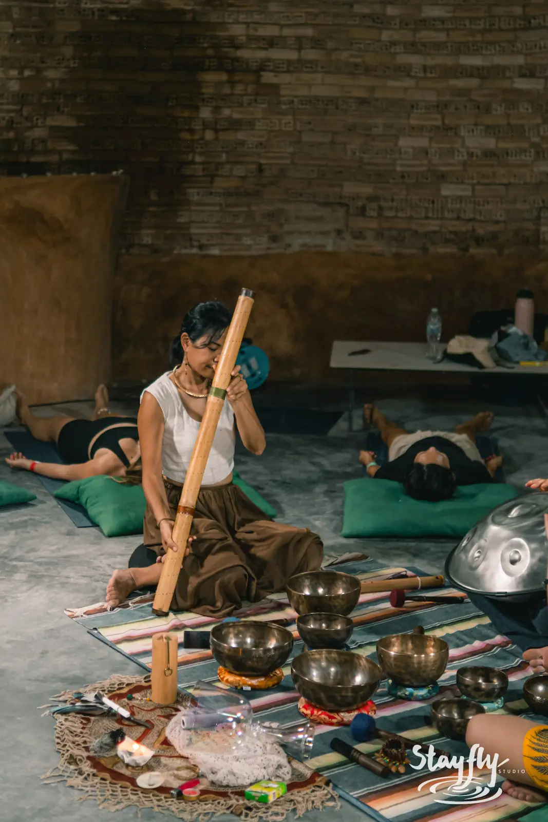 Woman plays bamboo instrument during sound healing.