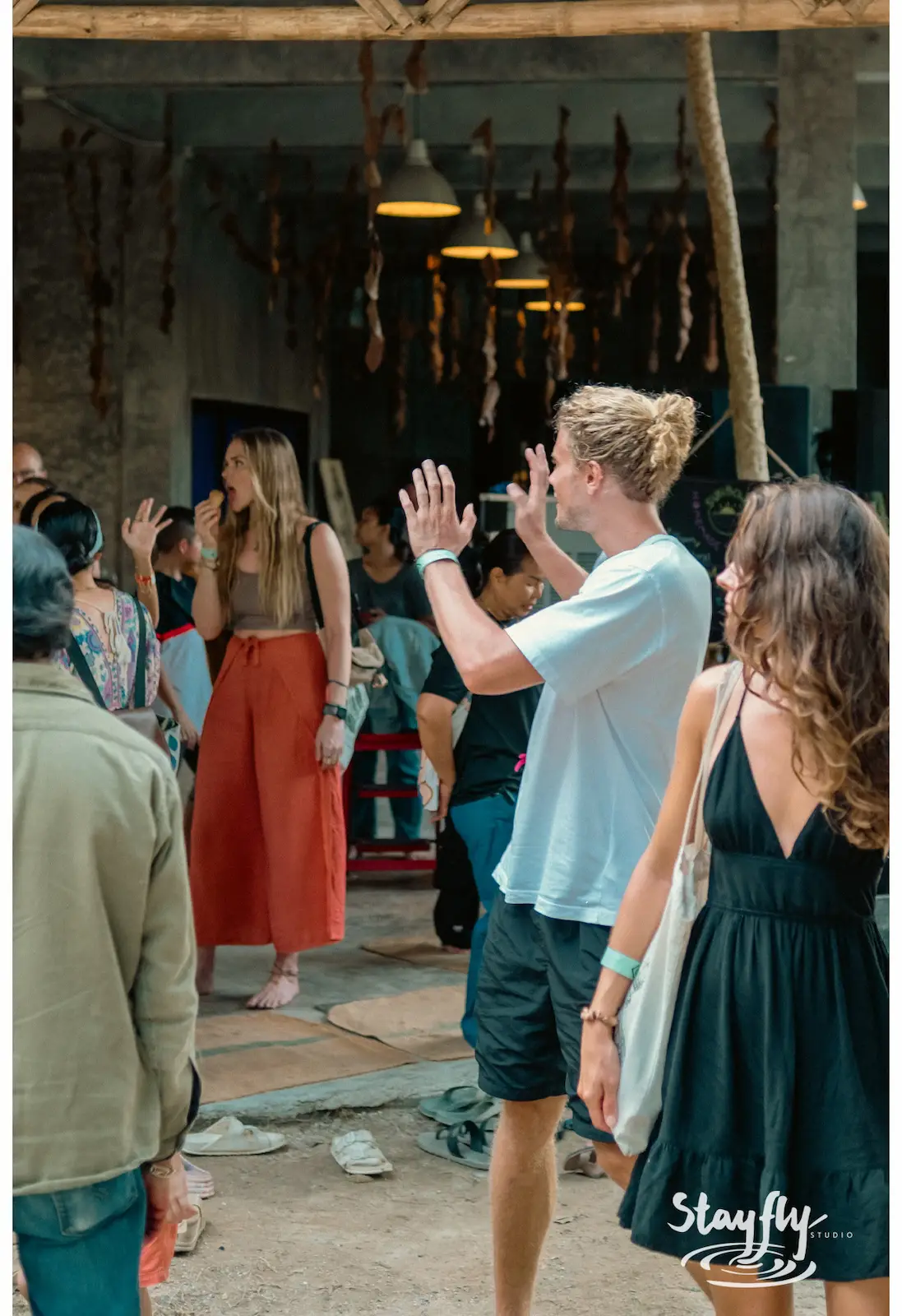 Crowd high-fiving inside industrial building, another angle.