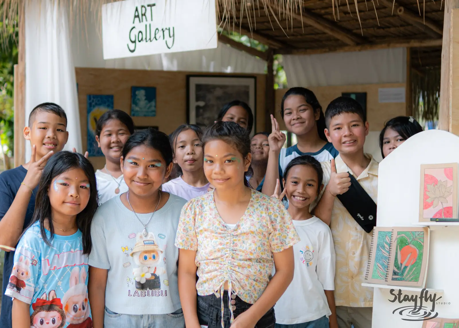 Children pose smiling by Art Gallery sign.