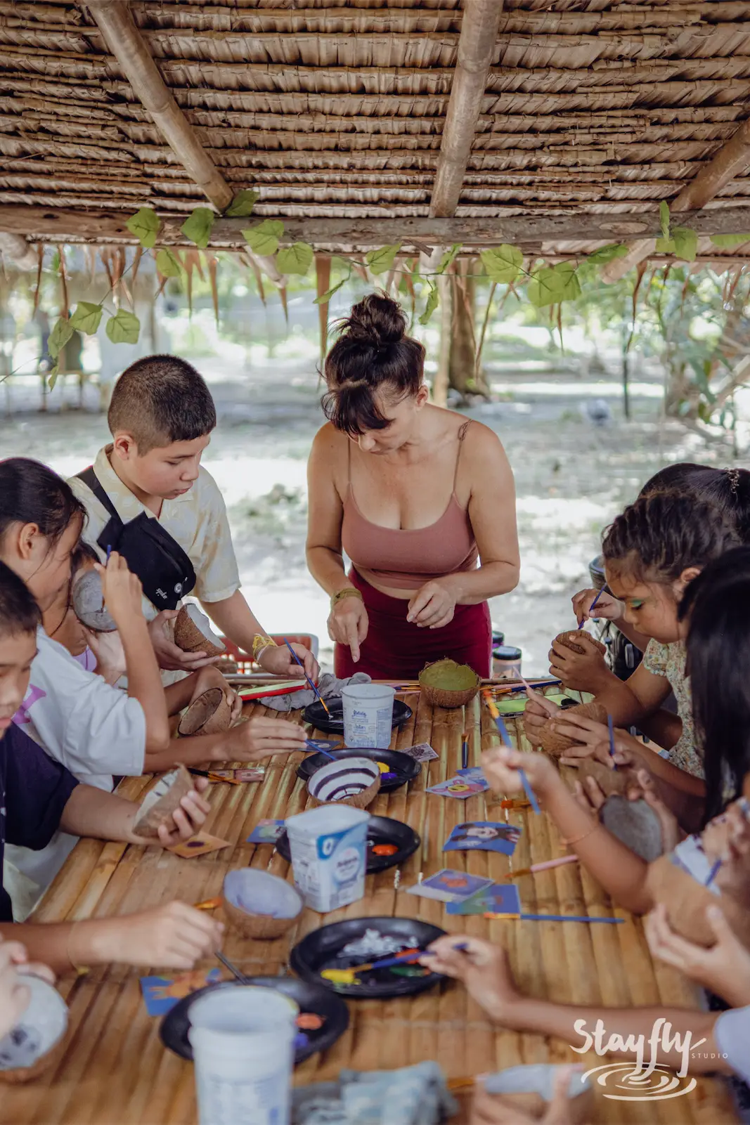 Woman leads children in a craft workshop.