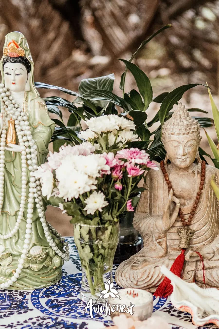 Buddha and Kuan Yin statues with flowers altar.