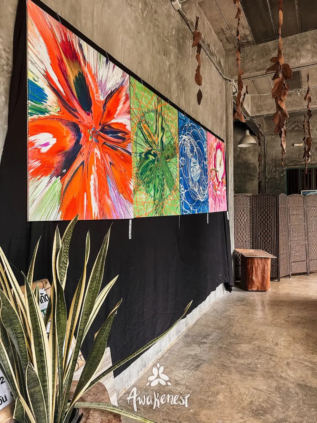Colorful painted panels hang in covered walkway.