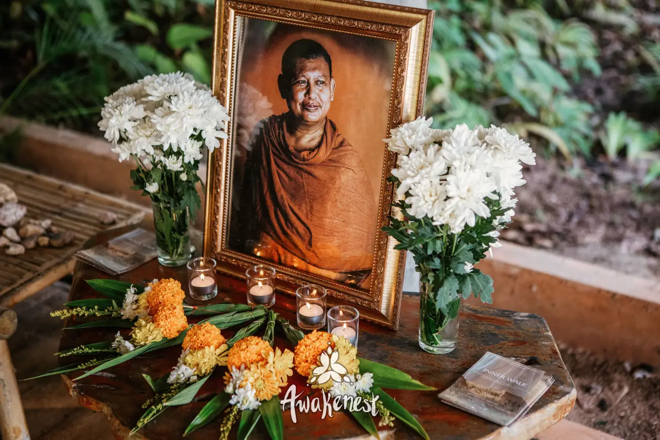 Memorial altar with monk portrait and flowers.