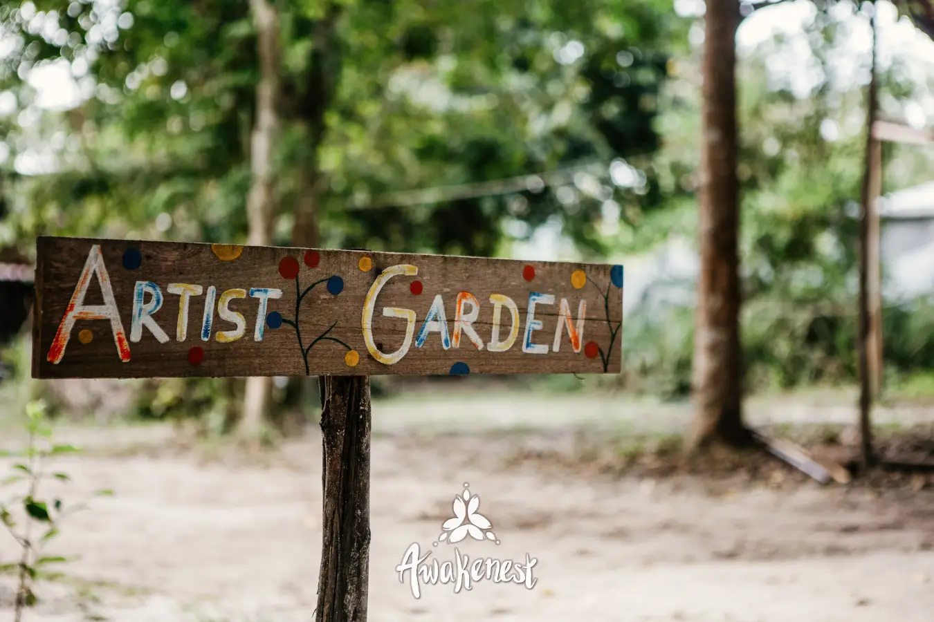 Hand-painted Artist Garden signpost among trees.
